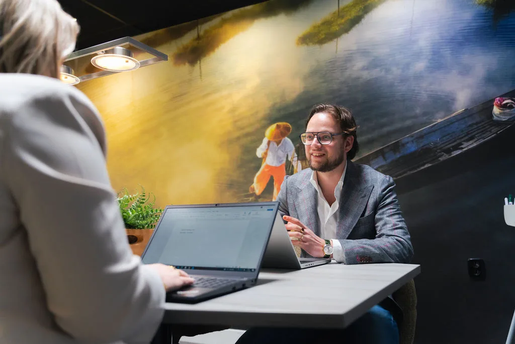 Klantgesprek aan tafel met laptop
