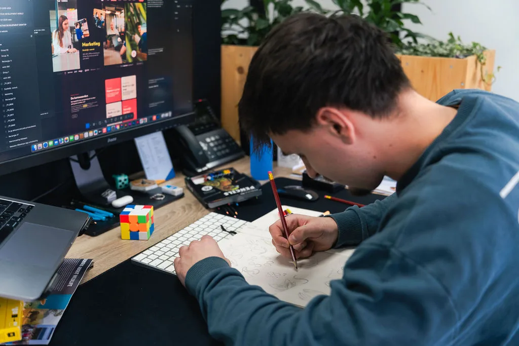 Ontwerper schetst een idee naast het beeldscherm